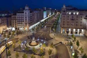 a city at night with a fountain and buildings at Apartamentos Plaza España Deluxe in Zaragoza