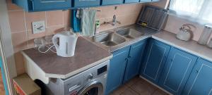 uma pequena cozinha com um lavatório e uma máquina de lavar roupa em Alpero Umtentweni em Port Shepstone