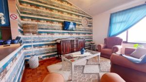 a living room with a brick wall with a fireplace at Alpero Umtentweni in Port Shepstone