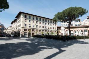 duży biały budynek z drzewem przed nim w obiekcie 2 Rooms next to a market and Piazza Santa Croce - HomeUnity we Florencji