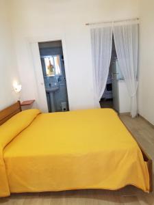 ポンツァにあるCasadelpino Residence La Pianaのベッドルーム1室(黄色いベッド1台付)