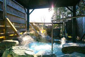 a pool of water with rocks in front of a building at 天からの贈り物 VillaMontpetre in Kirishima