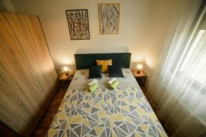 Unikat Zlatibor في زلاتيبور: غرفة نوم صغيرة مع سرير مع مصباحين