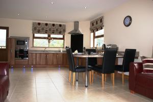a kitchen and dining room with a table and chairs at Glendun Self Catering in Cushendall