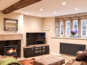 a living room with a fireplace and a flat screen tv at Newlands Farm Cottage Halifax in Luddenden Foot