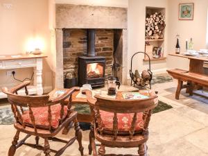 sala de estar con mesa de madera y chimenea en Newlands Farm Cottage Halifax, en Luddenden Foot