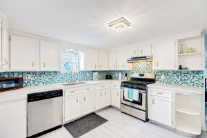 a white kitchen with white cabinets and appliances at Ocean Waves in Galveston