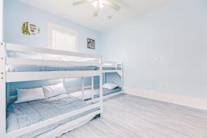 two bunk beds in a room with a ceiling fan at Ocean Waves in Galveston
