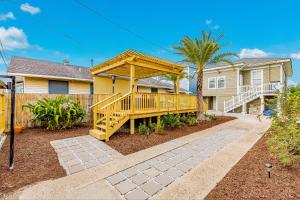 a house with a wooden deck with a gazebo at Ocean Waves in Galveston