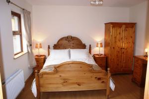 a bedroom with a wooden bed and two night stands at Glendun Self Catering in Cushendall