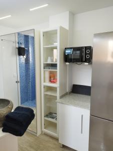 a small kitchen with a refrigerator and a microwave at Altozano Room II, Estudió centro de Málaga Gayfriendly, Wi-Fi gratis in Málaga