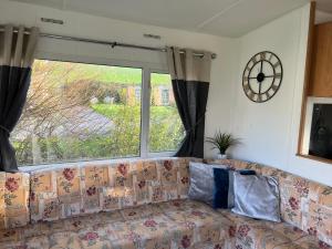 a couch in a living room with a large window at Cornish coastal retreats- 74 newquay view in Porth
