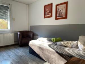 ein Zimmer mit 2 Betten und einem Stuhl darin in der Unterkunft Pension Paladi in Lauta