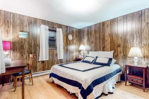 1 dormitorio con 1 cama y pared de madera en Lake Harmony - Pineknoll Drive Retreat en Lake Harmony