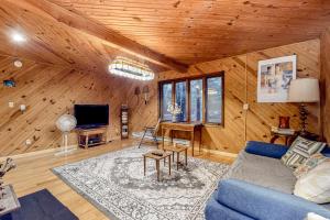 a living room with a blue couch and a tv at Lake Harmony - Pineknoll Drive Retreat in Lake Harmony