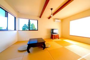 a living room with a table and a tv at 天からの贈り物 VillaMontpetre in Kirishima