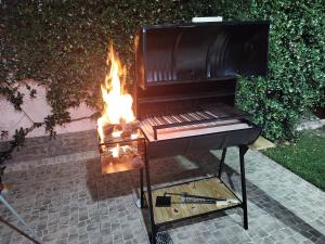 a barbecue grill with a fire in a backyard at EDU's HOUSE I in Guaymallen