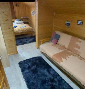 Habitación pequeña con 2 camas y alfombra. en Sadiba Rozchil, en Yablunytsya