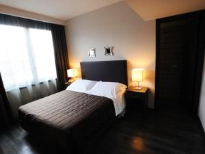a bedroom with a bed with two lamps on it at Park Hotel Sporting in Teramo