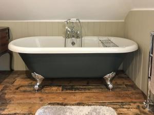 a bath tub sitting on a wooden floor in a bathroom at Old Rectory Loft in Fernhurst