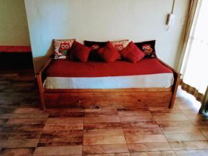 una cama con almohadas rojas en una habitación en Casona Alma en Calma San Rafael en San Rafael