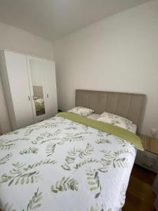 ein Schlafzimmer mit einem Bett mit einer grünen und weißen Decke in der Unterkunft FALCON in Banja Luka