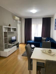 ein Wohnzimmer mit einem blauen Sofa und einem Tisch in der Unterkunft FALCON in Banja Luka