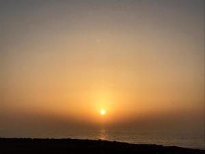 een zonsondergang boven de oceaan met de zon in de lucht bij Mirleft Trip in Mirleft