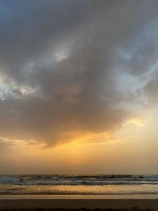 een persoon die bij zonsondergang op het strand loopt bij Mirleft Trip in Mirleft