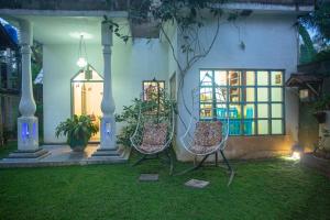 two chairs sitting in the yard of a house at night at Percy Residence in Unawatuna