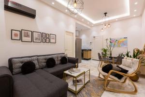 Airport Apartment Suite Casablanca FREE WIFI Modern Confort Calme في Derroua: غرفة معيشة مع أريكة وكراسي وطاولة