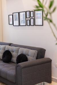- un canapé dans le salon avec des photos sur le mur dans l'établissement Airport Apartment Suite Casablanca FREE WIFI Modern Confort Calme, à Derroua