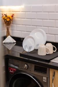 DerrouaにあるAirport Apartment Suite Casablanca FREE WIFI Modern Confort Calmeの電子レンジの上に座った2皿とマグカップ +46枚の写真