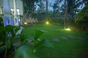 a backyard with a lawn with lights and a playground at Percy Residence in Unawatuna