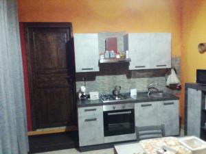 una cucina con lavandino e piano cottura forno superiore di Casa vacanza da Rosy a Gonnosfanàdiga