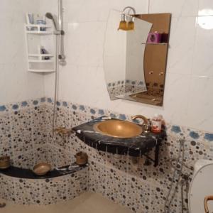 ein Bad mit einem Waschbecken und einem Spiegel in der Unterkunft Raha in Fès