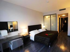 a hotel room with a bed and a desk with a bed sidx sidx sidx at Park Hotel Sporting in Teramo