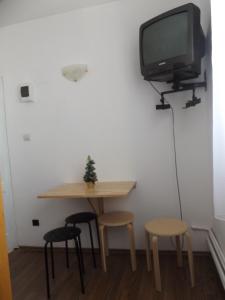 a small table with stools and a tv on a wall at Cabana Telescaun in Petroşani