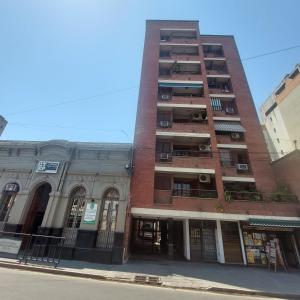 un edificio alto de ladrillo al lado de una calle en El apartamento de Teddy en San Miguel de Tucumán