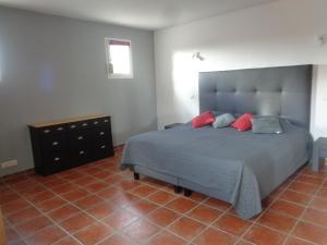 - une chambre avec un grand lit et des oreillers rouges dans l'établissement Villa des Oléandres, à Floure