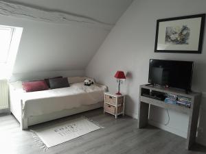 um pequeno quarto com uma cama e uma televisão em Escale Au Chiteau em Huisseau-sur-Cosson