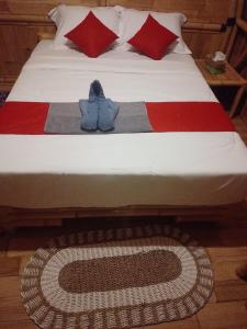 a bed with a blanket with a stuffed animal on it at Tegal Bamboo cottages & private hot spring in Baturaja