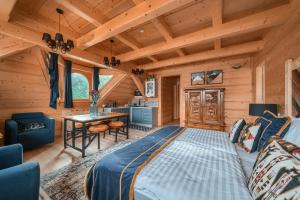 1 dormitorio en una cabaña de madera con 1 cama y 1 mesa en Rich Witch Villa&SPA, en Kościelisko