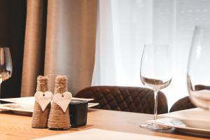 una mesa con dos portacorazones en una mesa con copas de vino en Imi Appartement, en Eben im Pongau