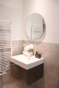 een badkamer met een wastafel en een spiegel bij Imi Appartement in Eben im Pongau