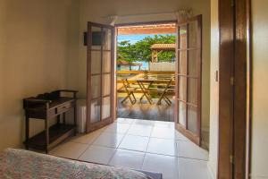 a room with a door open to a patio with a table at Geko Pousada Paraty in Paraty