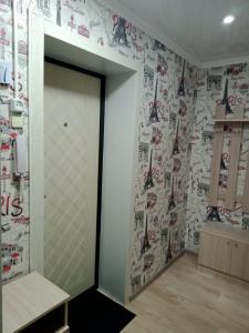 Una habitación con una pared con pegatinas de hockey. en Квартиры, en Shchūchīnsk