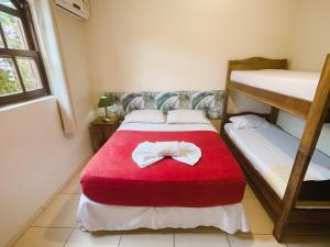 1 dormitorio con 2 literas y manta roja en Geko Pousada Paraty, en Paraty