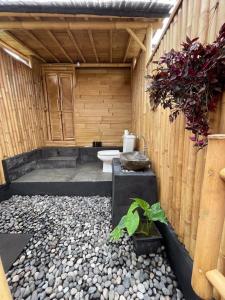 Tegal Bamboo cottages & private hot spring في Baturaja: حمام مع مرحاض في مبنى خشبي