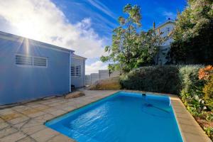 a swimming pool in a yard next to a building at Bahari Villa in Simonʼs Town